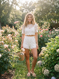 Woman wearing a floral lace cropped shirt and shorts set