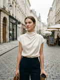 Woman wearing a draped high-neck cap-sleeve blouse