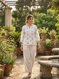 Woman wearing an embroidered floral cotton top and pants set