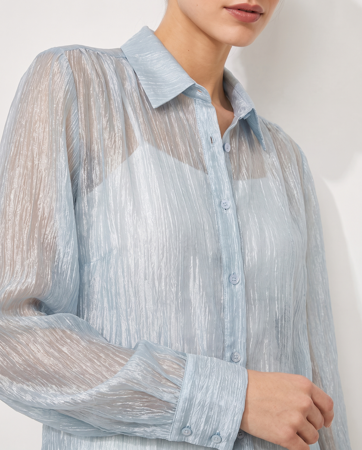 Collar and button detail of the semi-sheer blouse