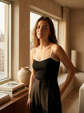 Woman wearing a black contrast trim knit strap top, front