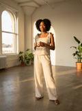 Woman wearing a beige tie-shoulder striped top and wide-leg pants set, front