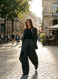 Woman wearing black asymmetric overlay balloon wide-leg pants, front
