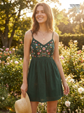 Woman wearing a green cotton floral embroidered cami mini dress, front