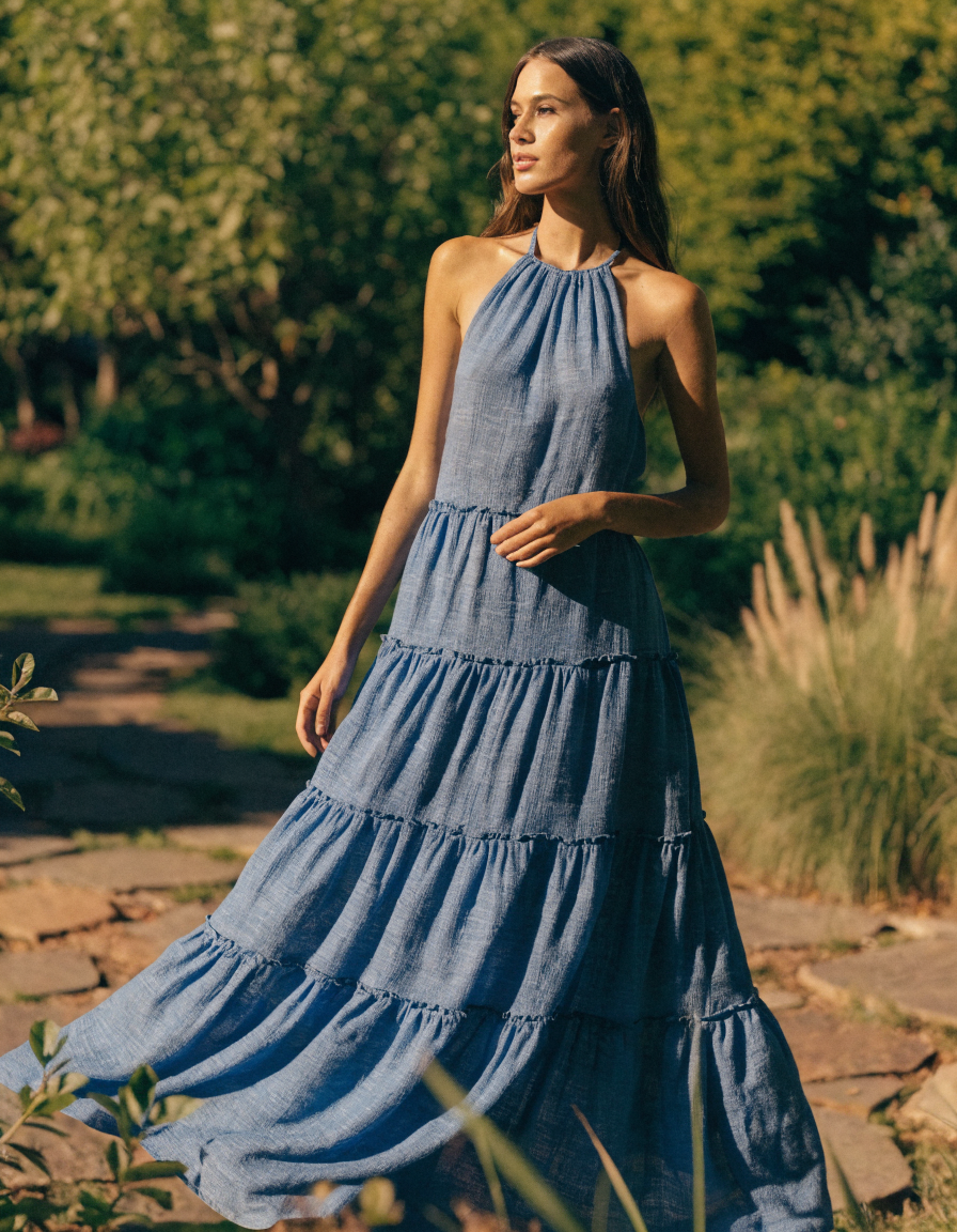 Blue halter neck tiered maxi dress in a sunlit garden