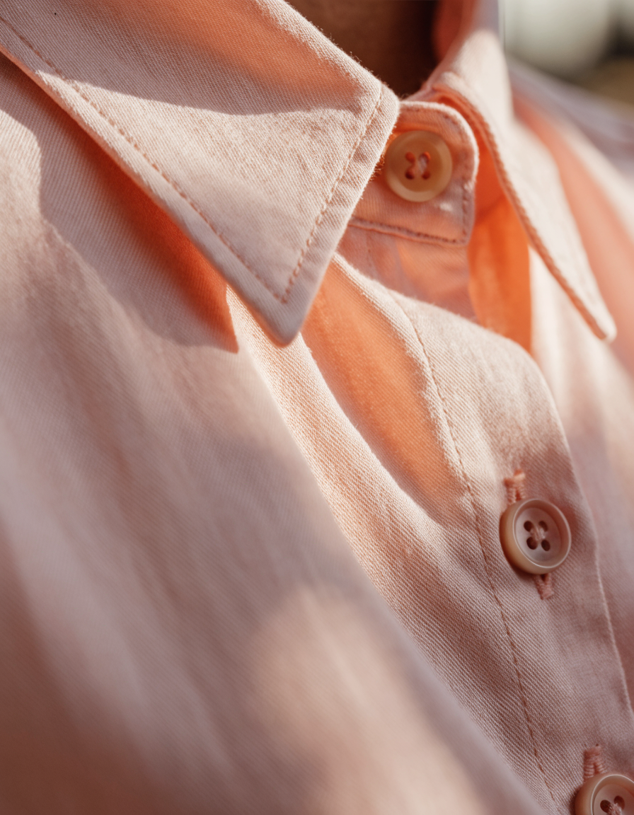 Detail of the collar and button placket of the pink woven shirt