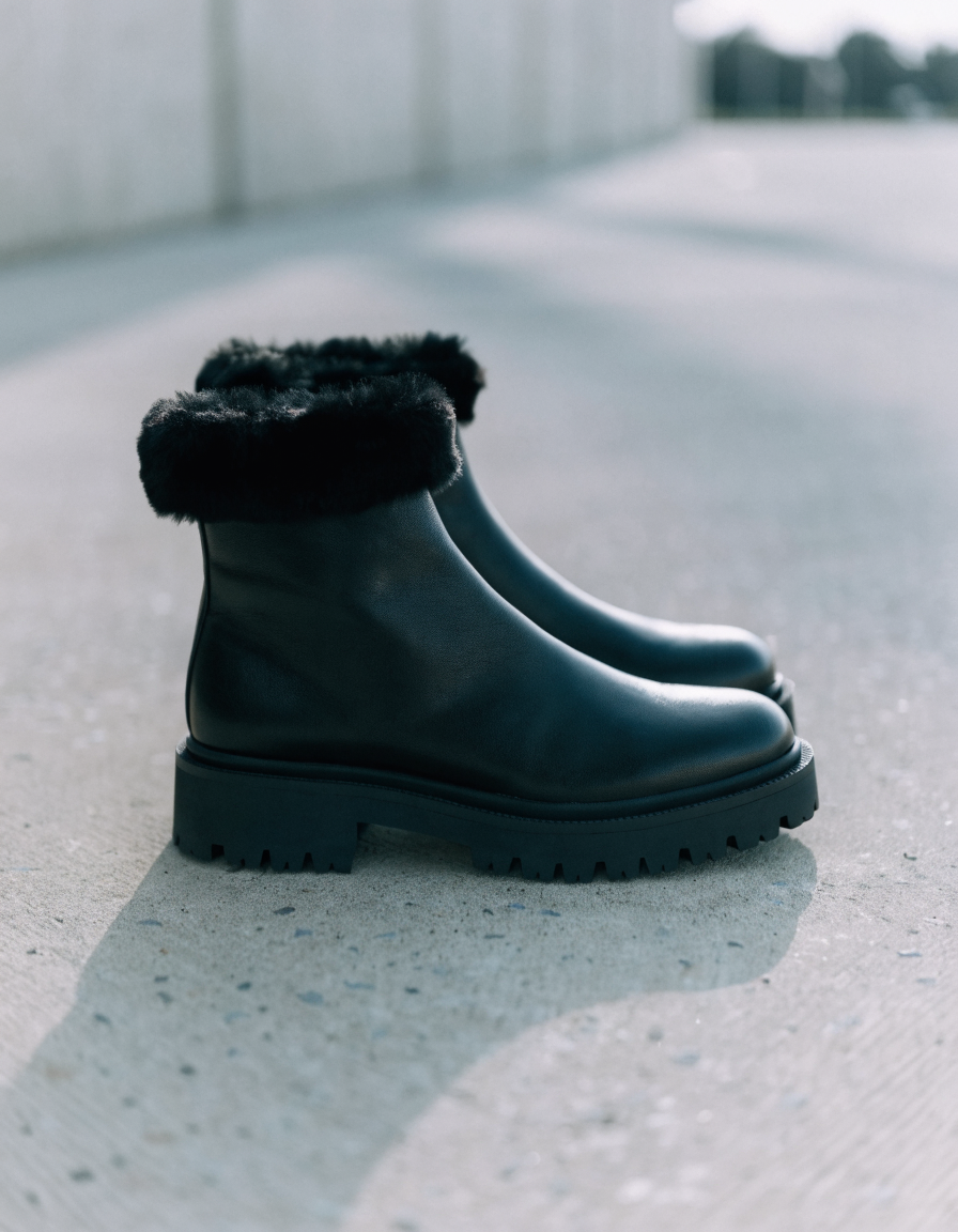 Black ankle boots with faux fur lined collar and chunky lug outsole