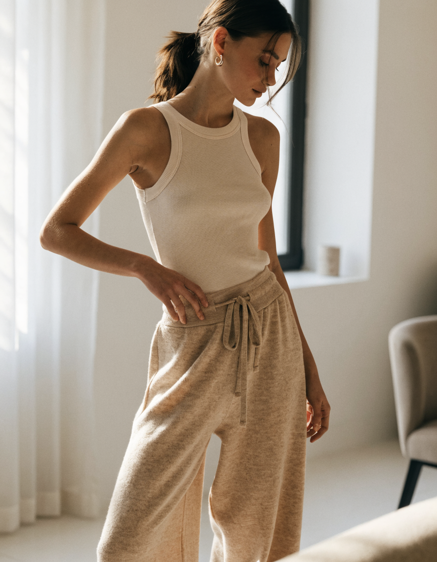 Woman wearing beige wide leg lounge knit pants with a drawstring waist